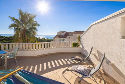a balcony with two chairs and a swimming pool at Apartments POLARIS in Baška Voda