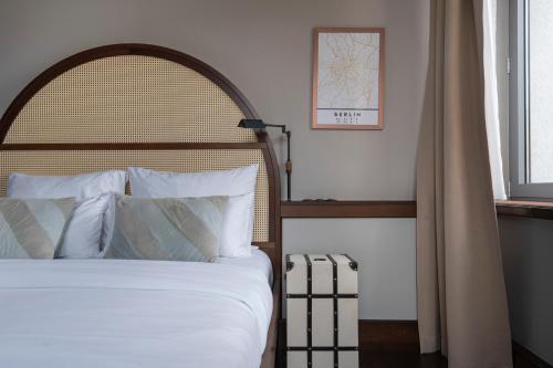 a bed with white sheets and pillows in a bedroom at Numa Berlin Potsdamer Platz in Berlin