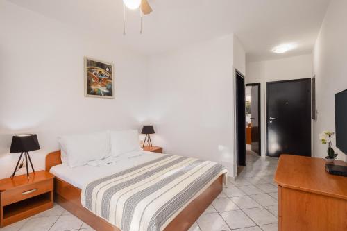 a bedroom with a bed and a desk and a television at Apartments POLARIS in Baška Voda