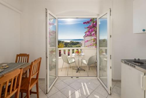 a kitchen with a balcony with a table and chairs at Apartments POLARIS in Baška Voda