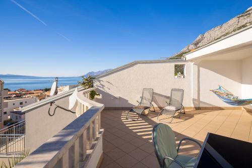 a balcony with chairs and a view of the ocean at Apartments POLARIS in Baška Voda