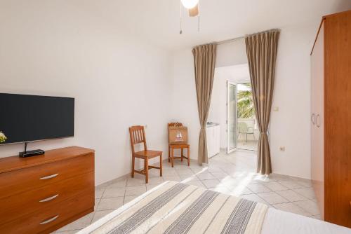 a bedroom with a flat screen tv on a dresser at Apartments POLARIS in Baška Voda