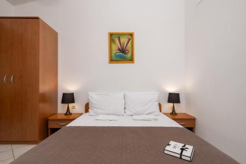 a bedroom with a bed and a picture on the wall at Apartments POLARIS in Baška Voda