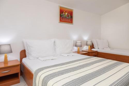 a bedroom with a bed and two night stands at Apartments POLARIS in Baška Voda