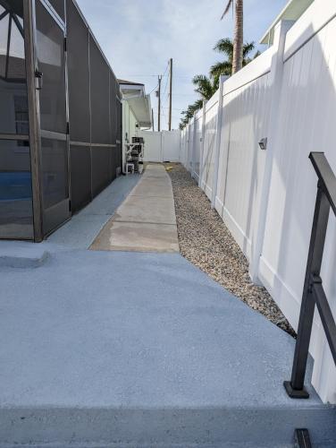 a long sidewalk next to a white fence at The Fish Shack in Saint James City