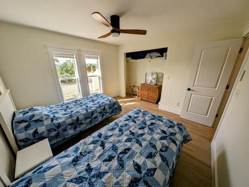 a bedroom with two beds and a ceiling fan at The Fish Shack in Saint James City