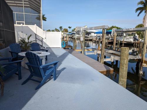a patio with two blue chairs and a table next to a marina at The Fish Shack in Saint James City
