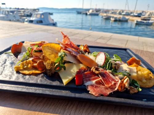 a plate of food on a table next to the water at Hotel Marina in Fažana