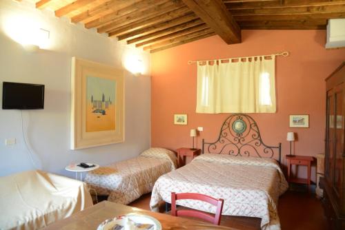 a hotel room with two beds and a table at B&B La corte di Stelio in Pisa