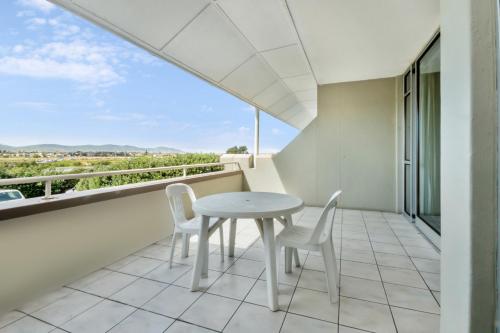 a white table and chairs on a balcony with a view at Dolphin Beach Hotel Self Catering Apartments in Bloubergstrand