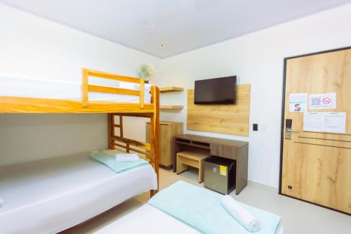 a small room with a bunk bed and a tv at Hotel Luna Verde in Doradal