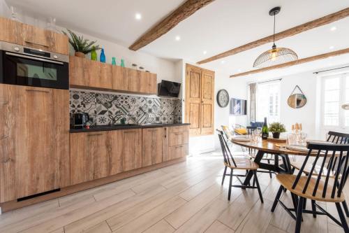 une cuisine avec des armoires en bois et une table avec des chaises dans l'établissement 3P Central Cannes Suquet, à Cannes