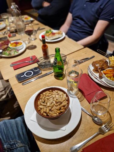 a wooden table with a bowl of nuts on it at Kyriad Carcassonne - Aéroport in Carcassonne