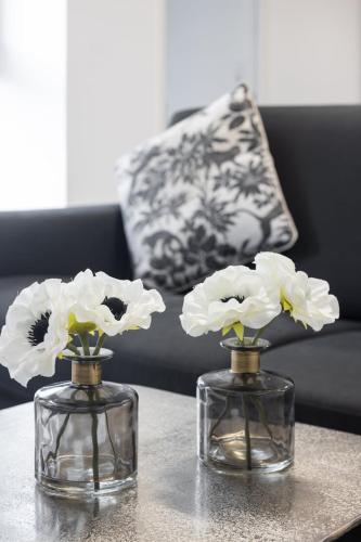 deux vases sur une table avec des fleurs blanches en eux dans l'établissement Suite Carla - Superbe appartement à Cannes, à Cannes