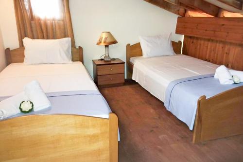 a bedroom with two beds and a lamp on a night stand at Chania's Diamond Villas - Aqua Bliss with Private Pools in Gavalochori