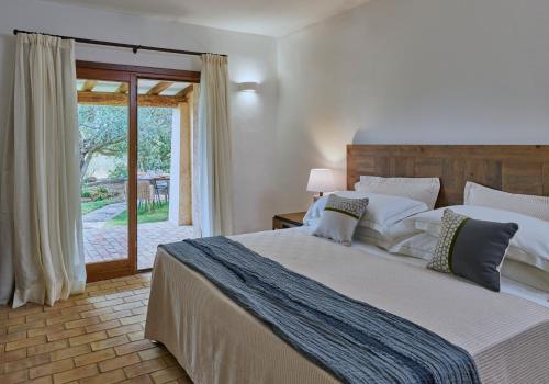 a bedroom with a large bed and a sliding glass door at Cascioni Eco Retreat in Arzachena