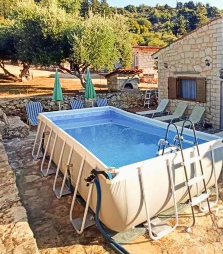 a pool in a yard with chairs and a house at Chania's Diamond Villas - Aqua Bliss with Private Pools in Gavalochori
