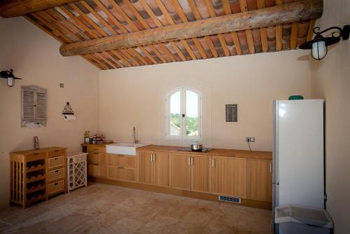 Il comprend une grande cuisine avec des placards en bois et un réfrigérateur. dans l'établissement La Collina De Rve, à Apt