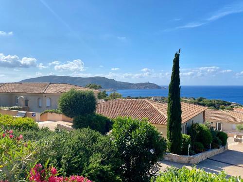 a view of the roofs of a house and the ocean at Calvi Résidence, Appart'hôtel in Calvi