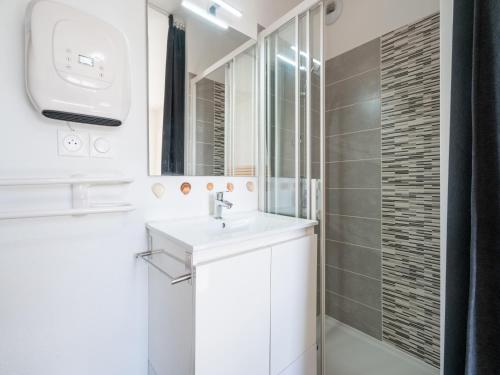 une salle de bain blanche avec un lavabo et un miroir dans l'établissement La Dune N 30 - Villa 4P8, à Sérignan