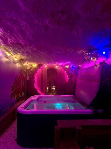 a purple room with a tub with lights in it at ZAJAZD ALBATROS Rzeszów SPA in Rzeszów