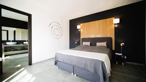 una camera da letto con un letto grande e un bagno di Villa Suarticcia, 6 pers, piscine chauffée, 3 min plage en voiture a Sainte-Lucie de Porto-Vecchio