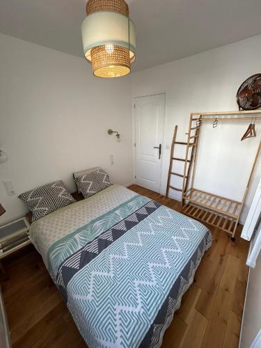 ein Schlafzimmer mit einem Bett und einer Leiter und einer Lampe in der Unterkunft Appartement lumineux Mairie des Lilas in Les Lilas