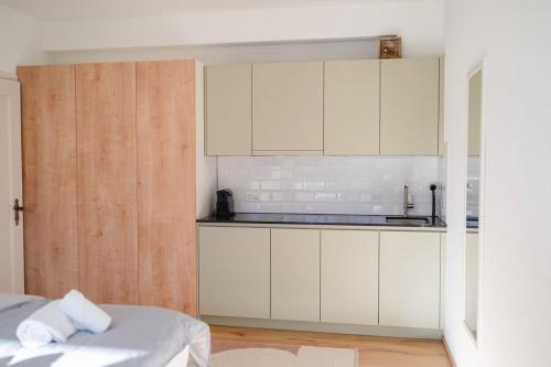 a kitchen with white cabinets and a bed in a room at Alpennest Arosa in Arosa