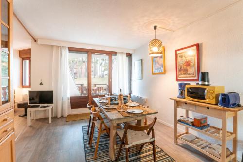 une salle à manger avec une table et un four micro-ondes dans l'établissement Le Devoluy, appartement pour 6 avec balcon, à Saint-Étienne-en-Dévoluy
