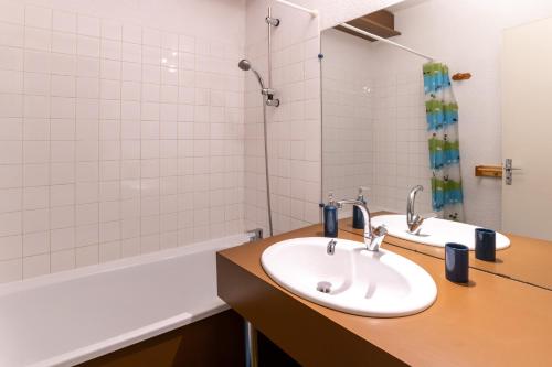 une salle de bain avec un lavabo et une baignoire dans l'établissement Le Devoluy, appartement pour 6 avec balcon, à Saint-Étienne-en-Dévoluy