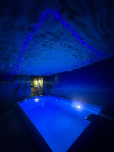 a dark room with a tub with blue lights at APARTAMENT Solny SPA in Rzeszów