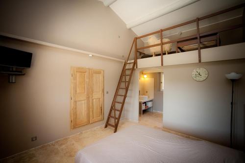 une chambre avec un lit superposé et une échelle dans l'établissement La Collina De Rve, à Apt