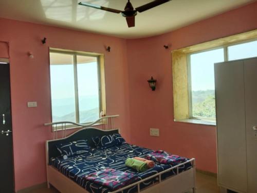 a bedroom with a bed in a room with windows at Dev anand Villa in Mahabaleshwar