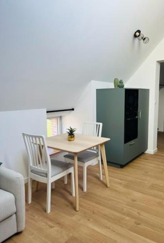 - une table et des chaises dans une pièce avec cuisine dans l'établissement Le Carcos, à Rocroi