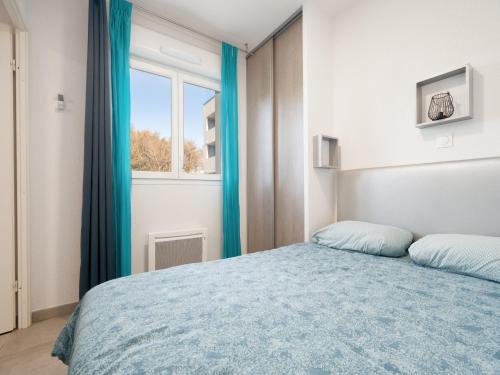une chambre avec un lit bleu et une fenêtre dans l'établissement La Dune N 12 - Villa 3P6, à Valras-Plage