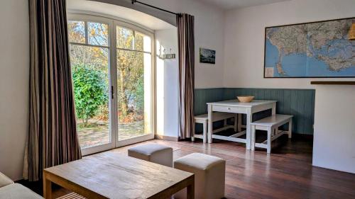 a living room with a table and a large window at Magnifique longère, proche plages et Vannes centre in Séné