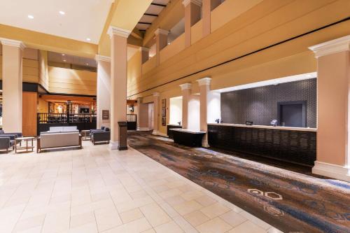 a lobby with a waiting area and a projection screen at DoubleTree by Hilton Tulsa Downtown in Tulsa