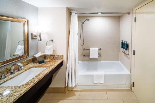 a bathroom with a large tub and a sink at DoubleTree by Hilton Tulsa Downtown in Tulsa