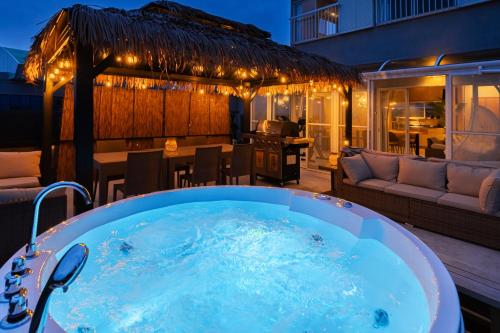 a jacuzzi tub on a deck with a patio at The BONDS SPAオーシャンプライベートヴィラー千葉白浜ー in Minamiboso