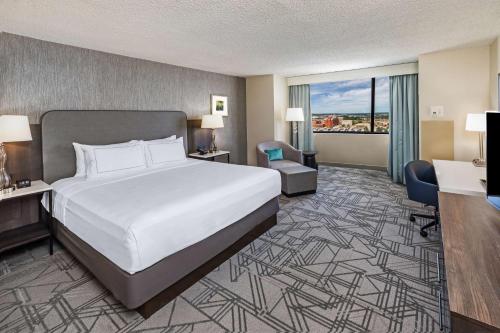 a hotel room with a large bed and a desk at DoubleTree by Hilton Tulsa Downtown in Tulsa
