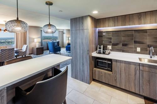 a kitchen with a sink and a counter with chairs at DoubleTree by Hilton Tulsa Downtown in Tulsa