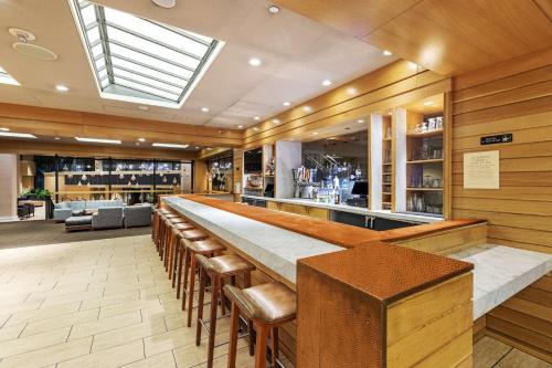 a bar with a long counter and some chairs at DoubleTree by Hilton Tulsa Downtown in Tulsa