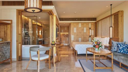 a hotel room with a bed and a bathroom at AYANA Segara Bali in Jimbaran