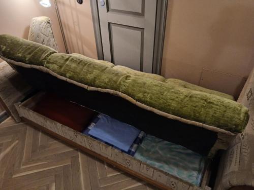 a bed with a green blanket on top of a floor at Parlament in Tallinn