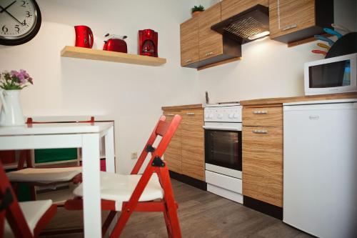 a kitchen with a red chair and a table at Ferienwohnungen und Ferienhäuser Gohr in Stralsund