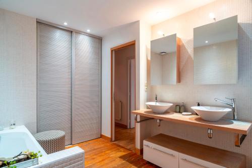 une salle de bain avec deux lavabos et une baignoire dans l'établissement L'Amiral Vannetais - Appt duplex au port de Vannes, à Vannes