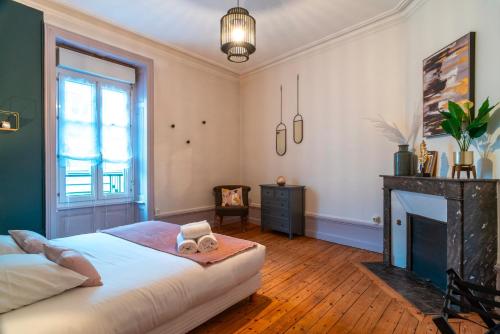 - une chambre avec un grand lit et une cheminée dans l'établissement L'Amiral Vannetais - Appt duplex au port de Vannes, à Vannes