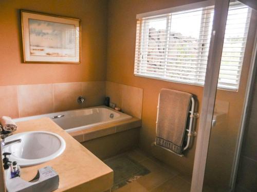 a bathroom with a sink and a bath tub at Watersmeet cottages in Dullstroom