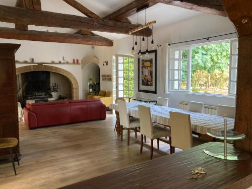 un salon avec une table et un canapé rouge dans l'établissement 757 Chemin du Vialat, à Boissières