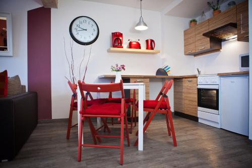 a kitchen with red chairs and a table with a clock at Ferienwohnungen und Ferienhäuser Gohr in Stralsund